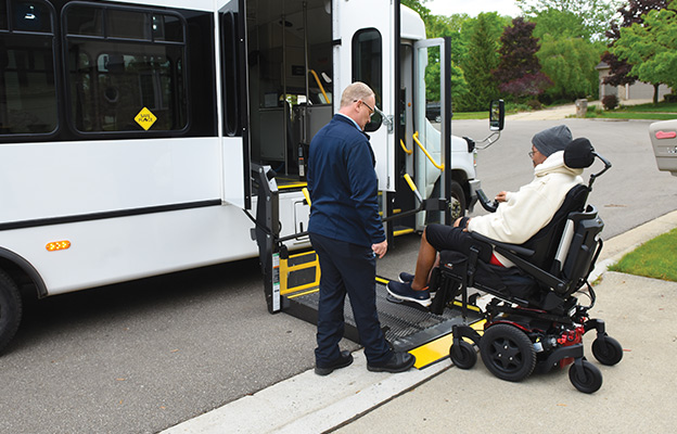 A person boarding a Spec-Tran bus with the lift