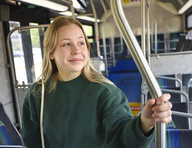 An MSU student standing on a campus bus