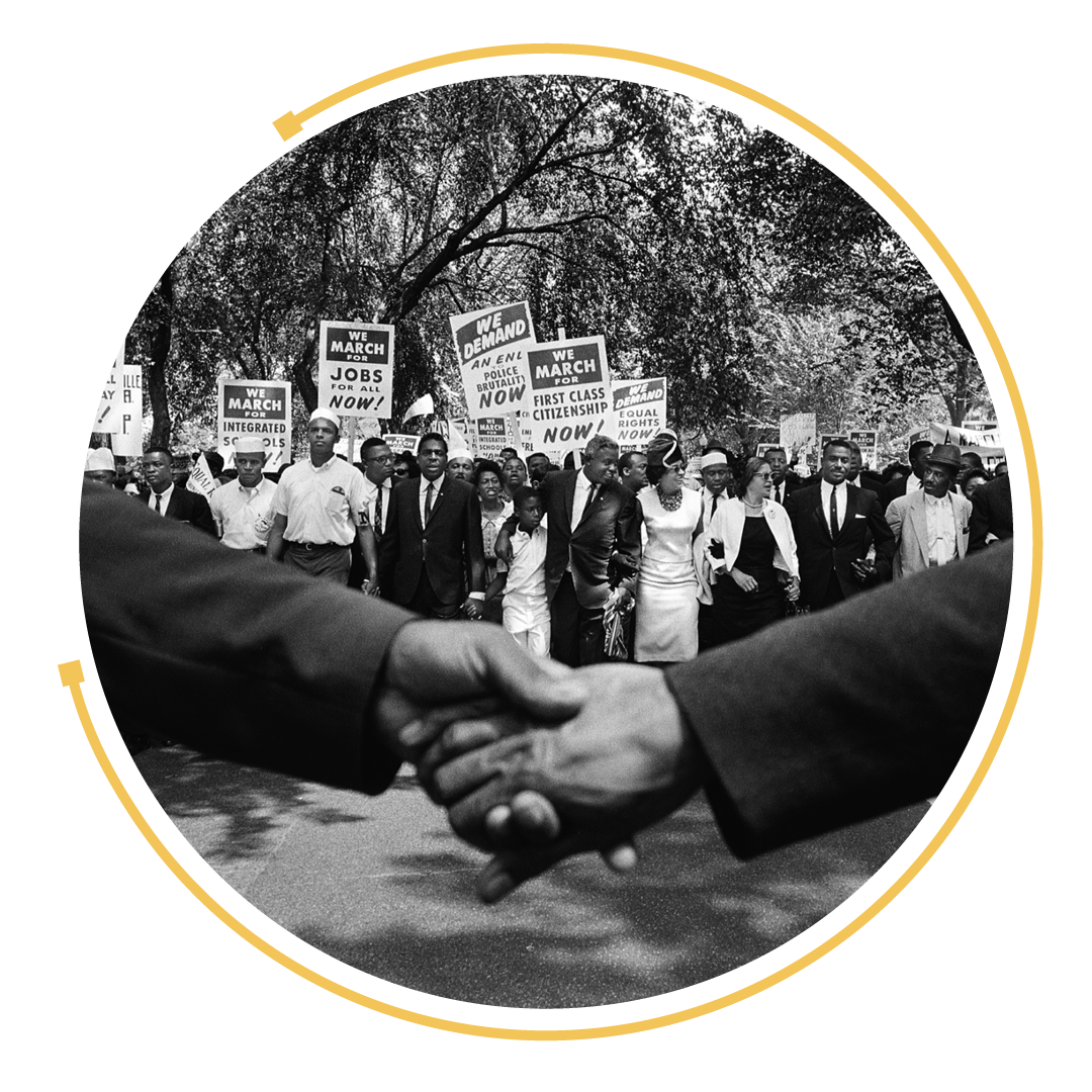 Two people shaking hands in front of members of the March on Washington